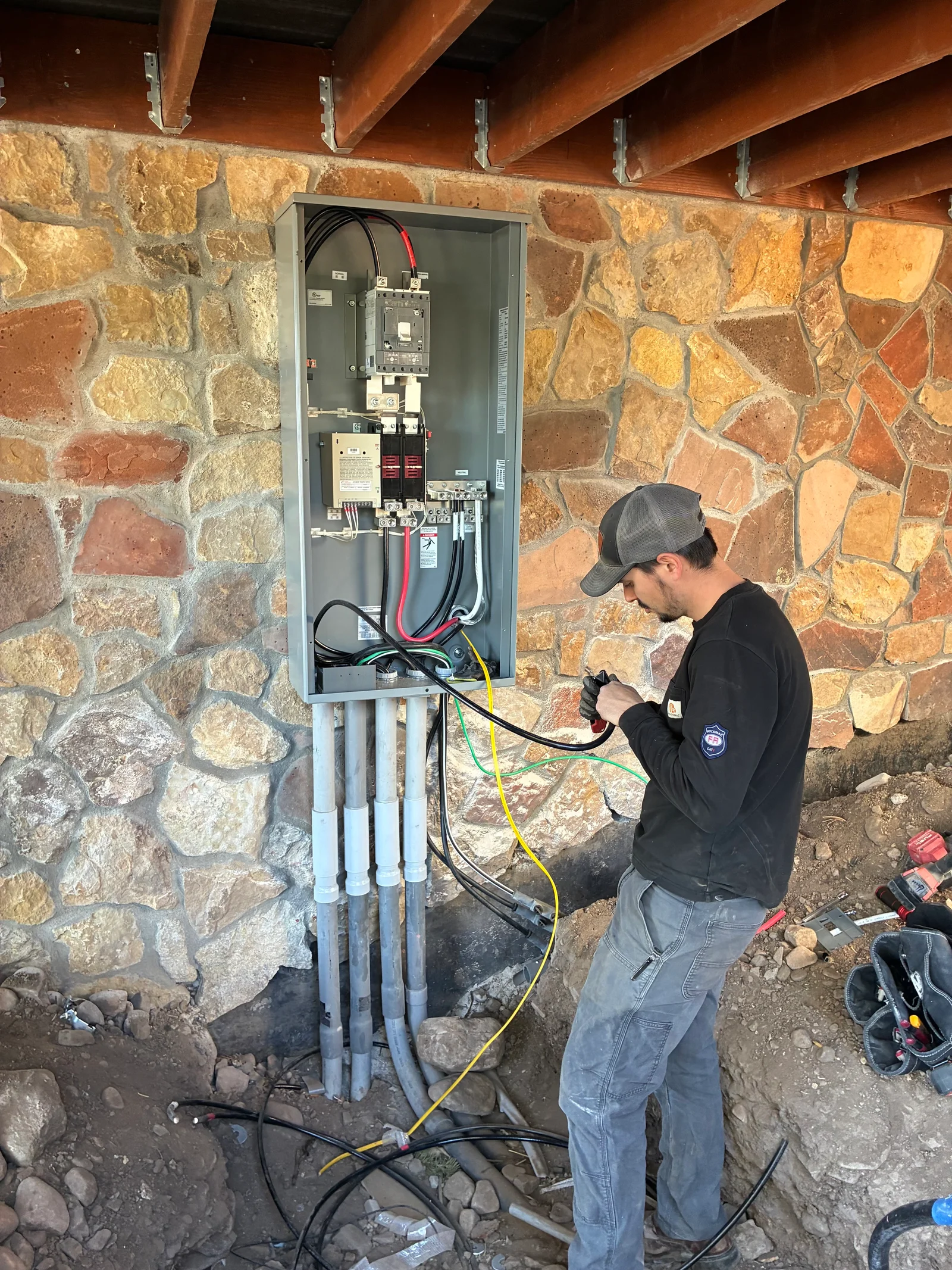 A newly installed residential electrical service panel mounted on an interior wall of a home in Westcliffe, Colorado, with organized circuit breakers and labeled branch circuits. The upgraded service entrance is visible, showing clean wiring runs suited to a rural Colorado property.